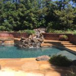 new pool with hot tub and rock fountain